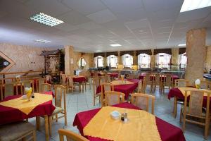 a dining room with tables and chairs with red table cloth at Pensjonat Borowik in Jelenia Góra-Jagniątków