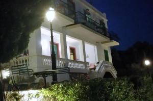 a white house with a light pole in front of it at Blue Dolphin in Batsi