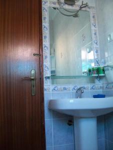La salle de bains est pourvue d'un lavabo et d'un miroir. dans l'établissement Pacheco's Guesthouse, à Lagos