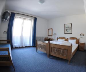 a bedroom with two beds and a large window at Gästehaus Obwexer in Matrei in Osttirol