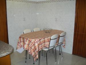 d'une table à manger entourée de chaises blanches. dans l'établissement Pacheco's Guesthouse, à Lagos