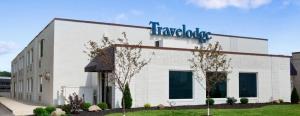 a large white building with a sign on it at Travelodge by Wyndham Hubbard OH in Hubbard
