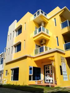 a yellow building with balconies on it at Good Time in Magong