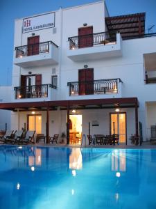 a hotel with a swimming pool in front of a building at Iliovasilema in Naxos Chora