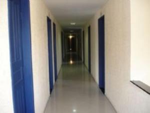 um corredor de um corredor com portas azuis e paredes brancas em Ferrari Palace Hotel em Boa Vista