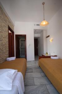 ナクソス・コラにあるIliovasilemaのベッド2台と照明付きのホテルルームです。