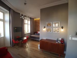 a living room with a bed and a table and chairs at Apartamenty Czapskich in Kraków