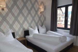 2 Betten in einem Zimmer mit Fenster in der Unterkunft Willa Port in Karwia