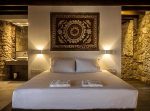 a bedroom with a large bed with two towels on it at Trinity Boutique Hotel in Rhodes Town