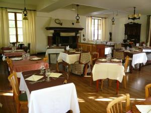 une salle à manger avec des tables, des chaises et une cheminée dans l'établissement Châlet Hôtel d'Ailefroide, à Ailefroide