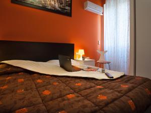 a bedroom with a bed with a laptop on it at Adriatic Room I in Ciampino