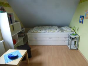 a small bedroom with a bed and a table at As bi uns to Huus in Wilhelmshaven