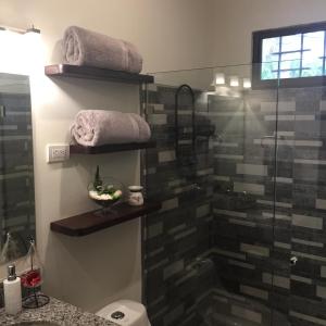 een badkamer met een douche, een toilet en handdoeken bij Guest House in Playa Flamingo