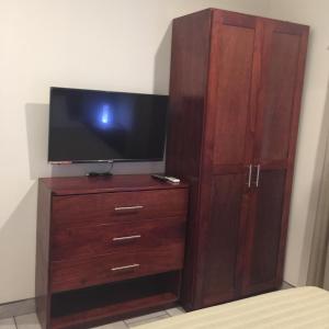 a large wooden entertainment center with a flat screen tv at Guest House in Playa Flamingo
