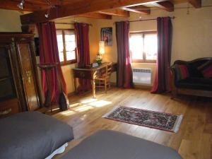 a room with a bed and a desk and windows at La Maison Jaune in Vendenheim
