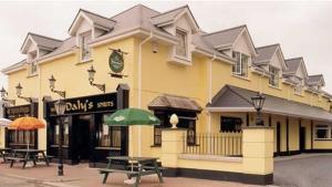 a yellow building with picnic tables in front of it at Dalys Inn in Donore