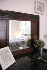 a mirror on a table with a bed in a bedroom at Goga&Romeo in Pesaro