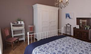 a bedroom with a bed and a chair and a chandelier at Goga&Romeo in Pesaro