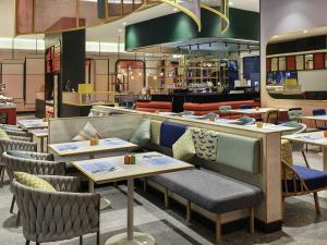 a restaurant with tables and chairs and a counter at ibis Styles Jakarta Tanah Abang in Jakarta