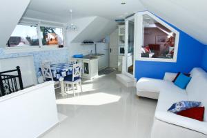 a living room with a white couch and a blue wall at Two rustikal apartments in Vila ''U Kali'' close to the beach, reserved parking place in Sveti Filip i Jakov
