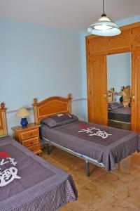 ネルハにあるVilla del Solのベッドルーム1室(ベッド2台、鏡付)