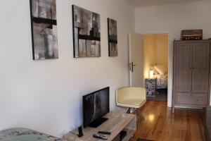 ein Wohnzimmer mit einem Flachbild-TV und einem Stuhl in der Unterkunft Bairro Alto Studios & Flats by Lisbon Village Apartments in Lissabon