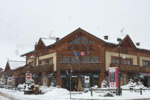 a large wooden building with snow on top of it at Appartamento Isola in Livigno