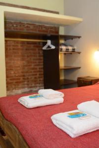 two towels are sitting on a red bed at Ayres de Cuyo in San Rafael