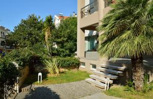 een gebouw met een bank naast een palmboom bij Urban 35 in Chania