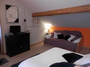 a hotel room with two beds and a television at Chambres d'Hôtes Roseland in Paray-le-Monial