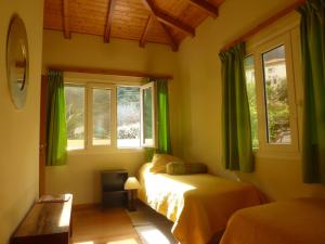 a bedroom with two beds and two windows at CASAS MARE , Ponta Delgada, Madeira in Ponta Delgada