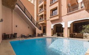 a swimming pool in front of a building at Marrakech House in Marrakesh