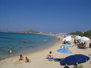 a group of people on a beach with umbrellas at Klimataria Studios in Agios Prokopios