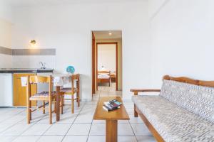 a living room with a couch and a table at Yiannis Ηotel in Arkasa