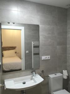 ein Badezimmer mit einem Waschbecken, einem WC und einem Spiegel in der Unterkunft Hostal Gargal in Olvega