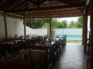 um restaurante com mesas e cadeiras e uma piscina em Ferrari Palace Hotel em Boa Vista