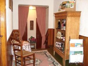 een kamer met een tafel en een stoel en een plank met wijnflessen bij Villa Louise in Bouillon