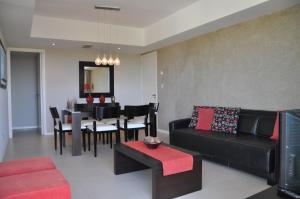 a living room with a couch and a dining room at Building Albar in Pinamar
