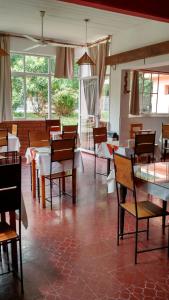 a dining room with tables and chairs and windows at Residencial Castelar in Merlo