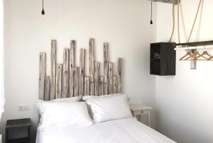 1 dormitorio con cama blanca y cabecero de madera en Hostal Gargal en Olvega