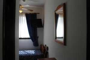 a room with a table and a mirror and a table and a television at La Vista Pension in Guía de Isora