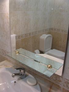 een badkamer met een wastafel en een spiegel en een toilet bij Apartamento Turf in Alvor