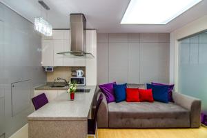 a living room with a couch and a kitchen at Highvill Deluxe Apartments in Astana