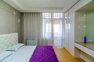 a bedroom with a white bed and a window at Highvill Deluxe Apartments in Astana +15 photos