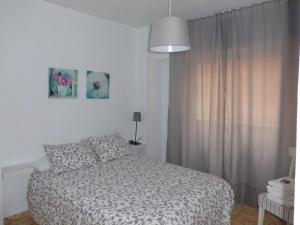 ein weißes Schlafzimmer mit einem Bett und einem Fenster in der Unterkunft Apartamento Gran Vía Cehegín in Cehegín
