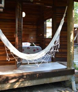 a hammock on the porch of a house at Pousadinha in Ilha do Mel