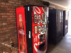 a cocacola soda machine next to a brick wall at Travel Inn & Suites in Atlanta