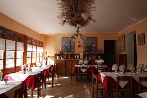 a dining room with tables with red and white tablecloths at Locanda del Pittore in Arcumeggia