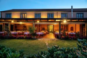 a hotel with tables and chairs on a patio at Agriturismo Biologico Corte Aragonese in Santa Maria di Licodia