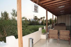 een veranda met stoelen en uitzicht op een tuin bij Roseland's Hotel in Marmari